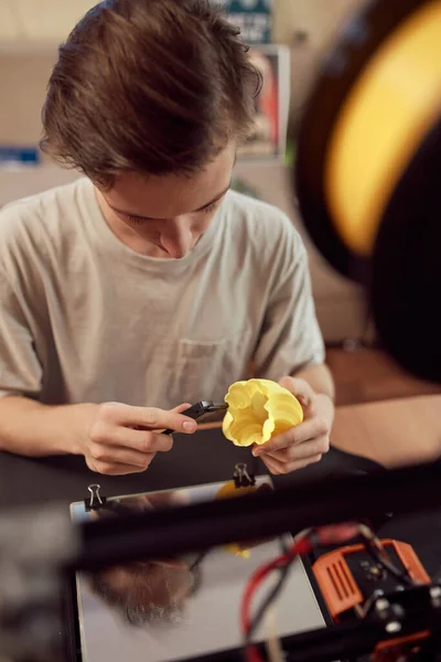 Chico joven cortando modelo plástico — Foto de Stock