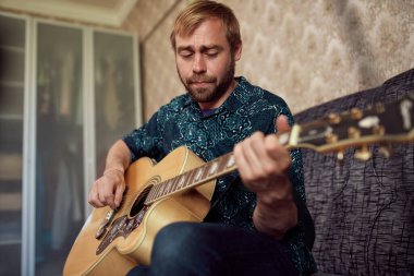 Gitar çalan ve prova sırasında şarkı söyleyen adam.