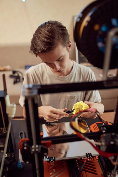 Молодой парень режет пластиковые модели — стоковое фото