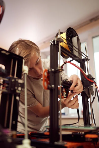 Joven técnico masculino fijando impresora 3D — Foto de Stock