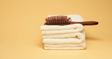 Sarı arka planda saç fırçası ve havlular. Asgari sağIık kavramı