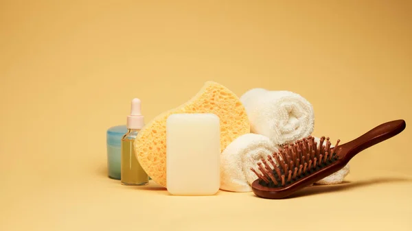 Aksesoris mandi dan spa. Sabun, handuk, spons tubuh, lotion, serum dan sikat rambut atas latar belakang kuning — Stok Foto