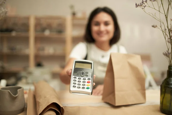 Craftswoman oferecendo terminal de pagamento para câmera — Fotografia de Stock