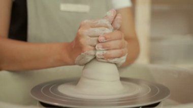 Çömlek çarkında kil kabı şekillendiren seramist