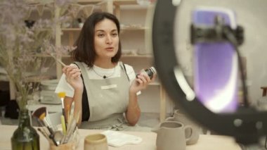 Artisan, çömlek atölyesinde vlog kaydı yapıyor.