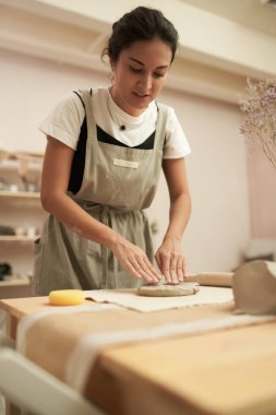 Seramikçi stüdyoda kil yoğuruyor.