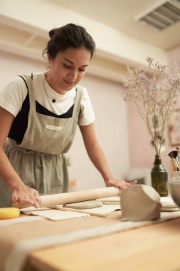Potter atölyesinde kil yuvarlıyor.