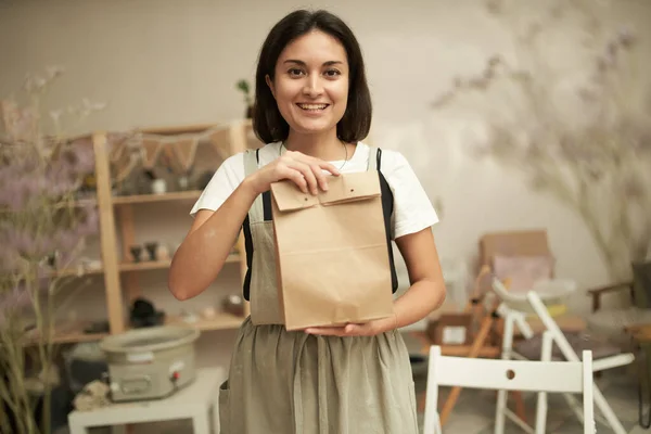 Przyjazny kobiecy rzemieślnik z papierową torbą — Zdjęcie stockowe
