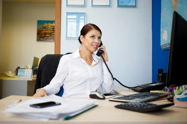 Retrato de jovem empresária falando por telefone no escritório — Fotografia de Stock