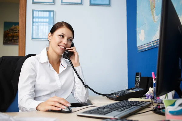 Portrait of young businesswoman talking on phone in office — Stock Photo, Image