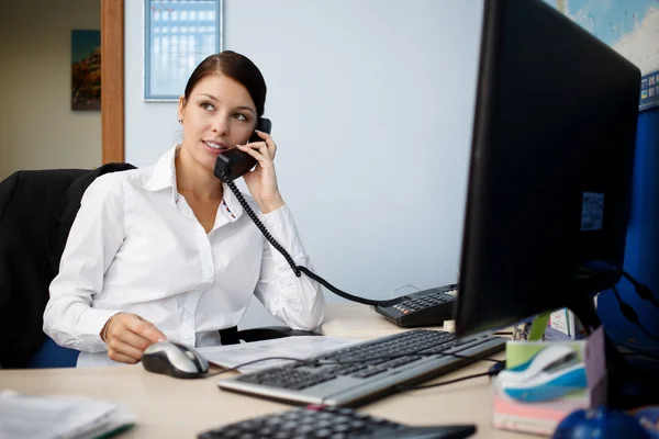 Portrait of young businesswoman talking on phone in office — Stock Photo, Image