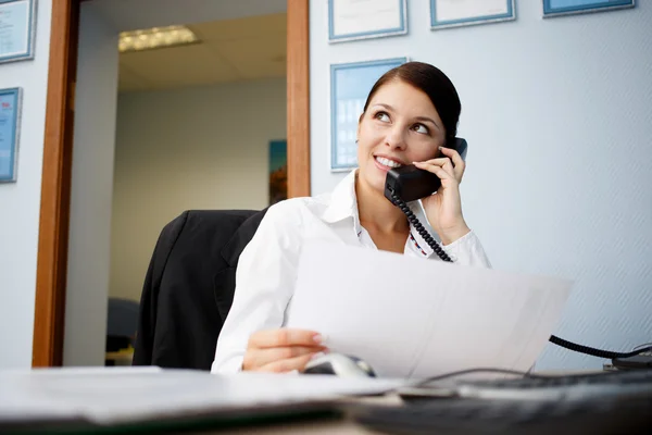 Retrato de jovem empresária falando por telefone no escritório — Fotografia de Stock