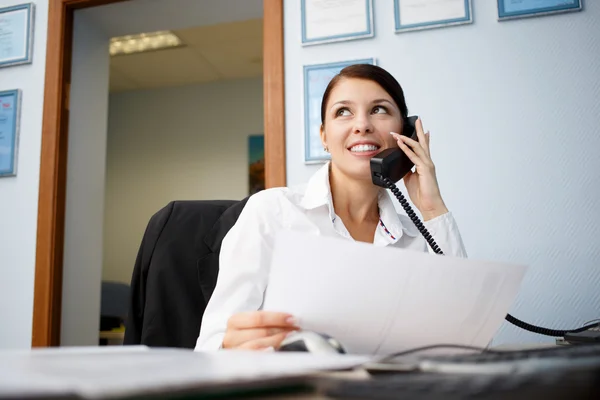 Retrato de jovem empresária falando por telefone no escritório — Fotografia de Stock