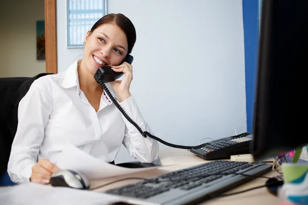 Retrato de jovem empresária falando por telefone no escritório — Fotografia de Stock