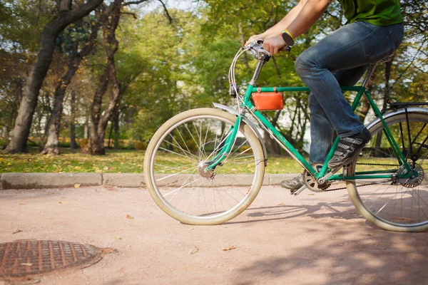 Nahaufnahme eines jungen Mannes, der im Park Fahrrad fährt — Stockfoto