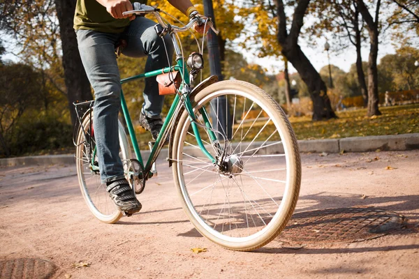 Närbild av ung man rida cykel i park — Stockfoto