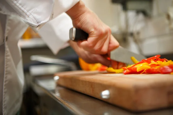 Close-up em mãos cortando pimentão amarelo — Fotografia de Stock