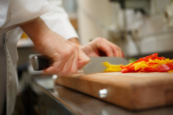 closeup on hands cutting yellow pepper