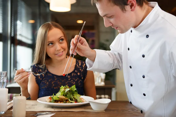 Kocken decorating sallad. — Stockfoto