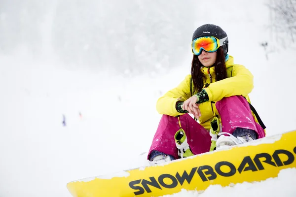 Snowboarder sentado na neve em altas montanhas — Fotografia de Stock