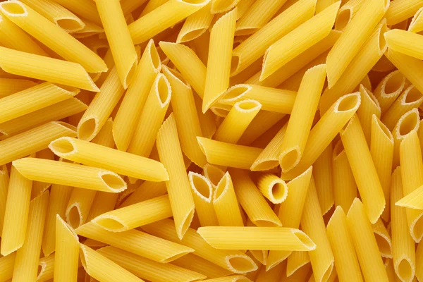 Backgrund of italian penne rigate pasta — Stock Photo, Image