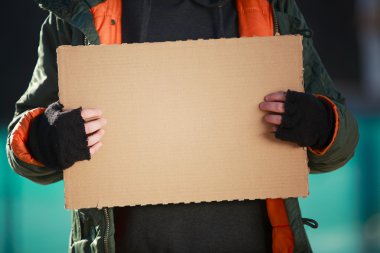 Evsiz bir adam kendi metniniz için boş karton tutan