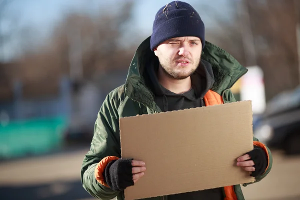 Hemlös man håller Tom kartong för egen text — Stockfoto