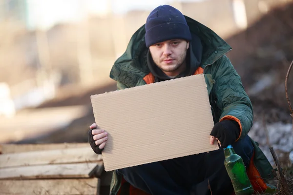 Hemlös man håller Tom kartong för din text — Stockfoto