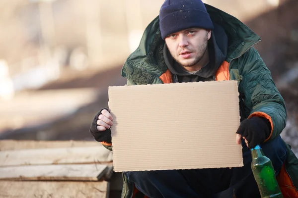 Hemlös man håller Tom kartong för din text — Stockfoto