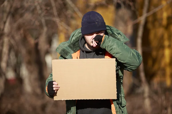 Homeless man holds blank cardboard for your own text — Stock Photo, Image