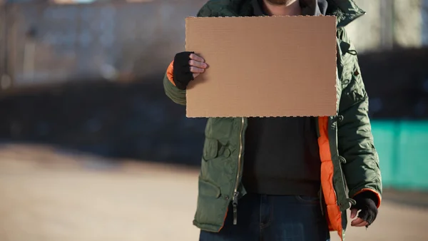 Hemlös man håller Tom kartong för egen text — Stockfoto