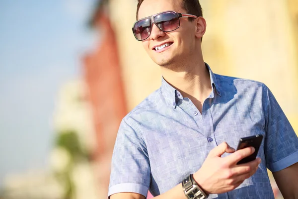 Outdoor portrait of man with mobile phone in the street. — Stock Photo, Image