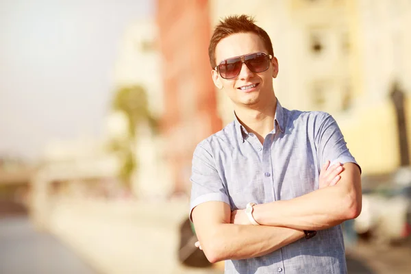 Porträtt av en stilig ung man med solglasögon — Stockfoto