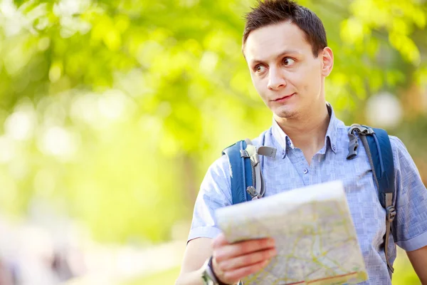 Young man with a map outdoors — Stock Photo, Image