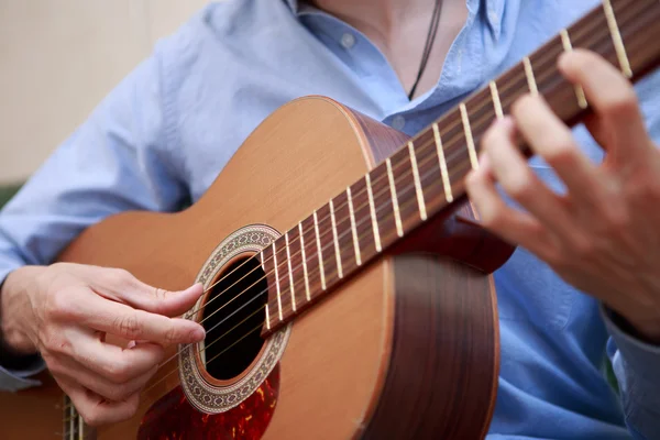 Человек играет на классической акустической гитаре — стоковое фото