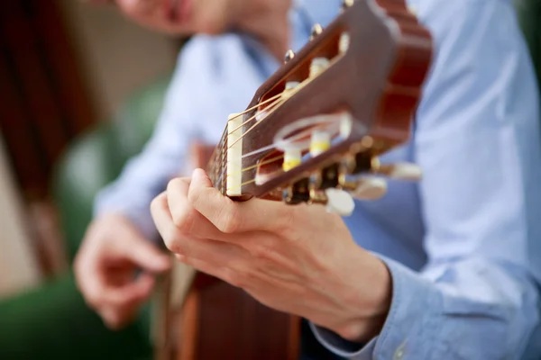 Young musician playing at acoustic guitar — Stock Photo, Image