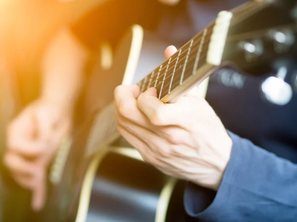 Mano masculina tocando la guitarra acústica. Primer plano . — Foto de Stock