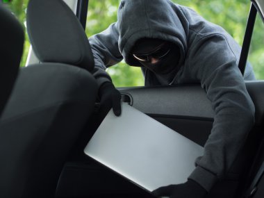 Araba hırsızlığı - boş bir araba pencereden varlık kaypak laptop.