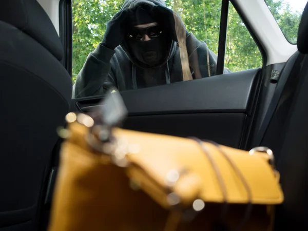 Transport brottslighet koncept. Tjuven stjäl väska från bilen — Stockfoto