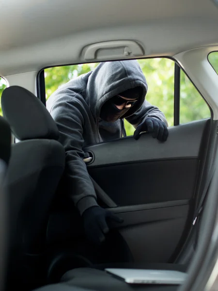 Autodiefstal - een laptop wordt gestolen door het raam van een leegstaande auto. — Stockfoto
