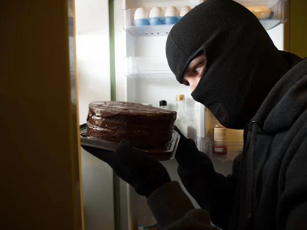 Tjuv. Mannen i svart mask med en tårta. — Stockfoto