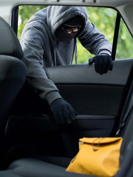 Μεταφορά έννοια του εγκλήματος. Κλέφτης κλέβει τη τσάντα από το αυτοκίνητο — Φωτογραφία Αρχείου