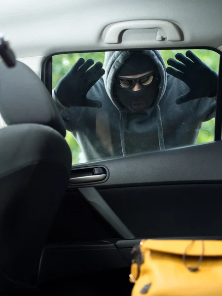 Transportation crime concept .Thief stealing bag from the car Stock Image