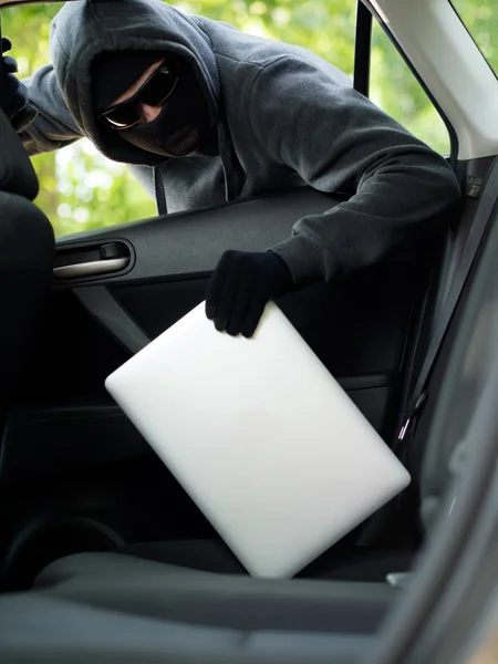 Car theft - a laptop being stolen through the window of an unoccupied car. — Stock Photo, Image