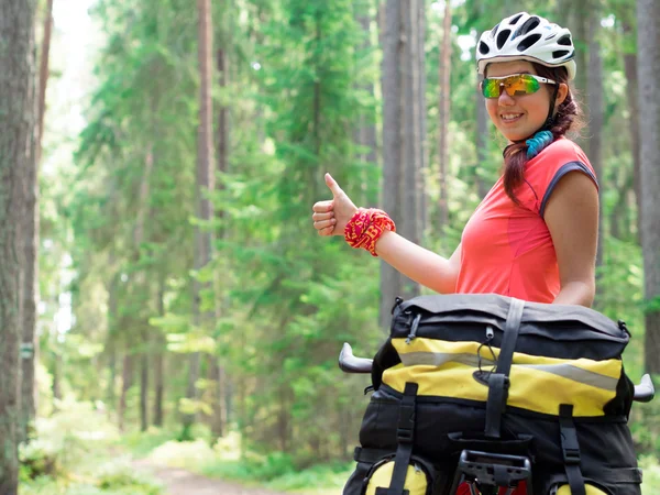 Woman riding a bike on the forest trail in sunny day — Stock Photo, Image