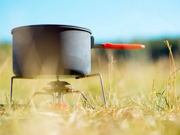 Lata no fogão de acampamento portátil — Fotografia de Stock