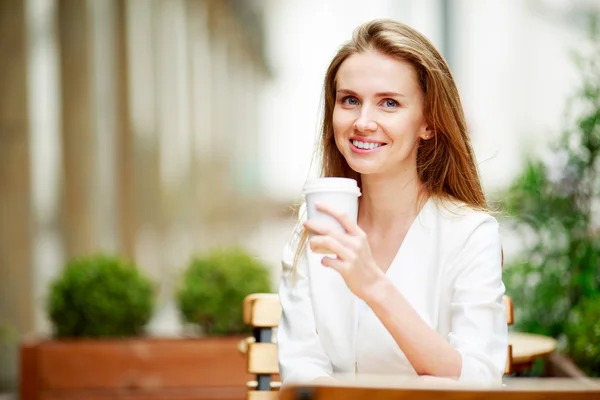 通りのカフェでコーヒーを飲む女性 ストック画像