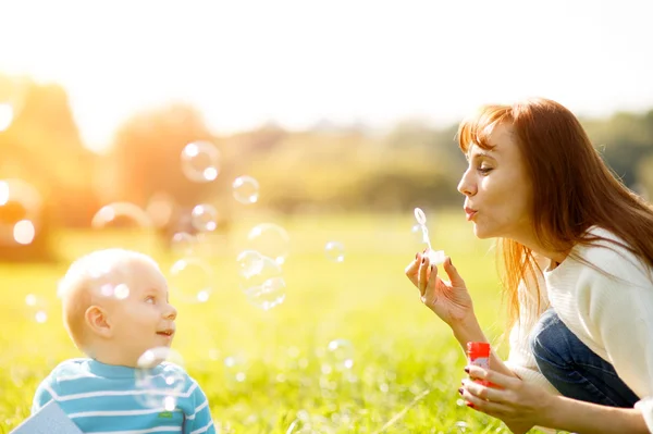 Moeder en zoon maken zeepbellen — Stockfoto