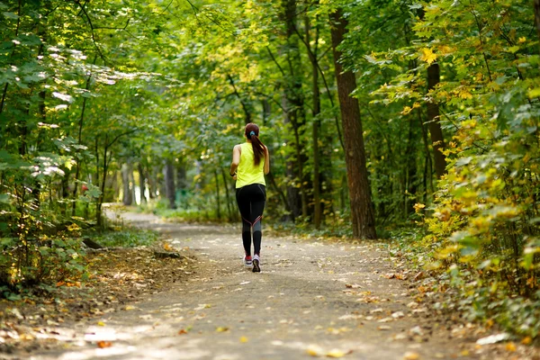 Kobieta biegnąca w lesie — Zdjęcie stockowe