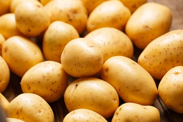 Potatoes on wooden background — Stock Photo, Image